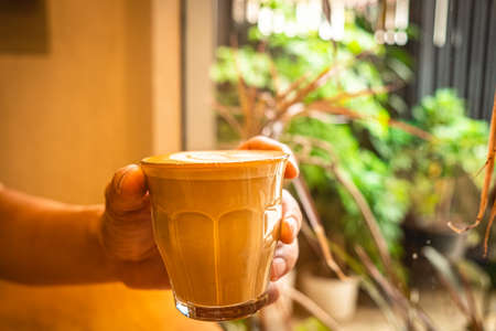 A cup of coffee latte top view with leaf shape foamの写真素材