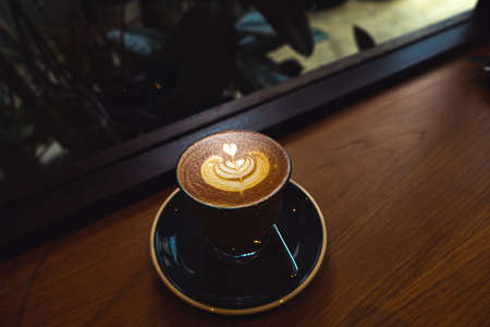 A cup of coffee latte top view with Microfoam milk leaf shape foam.の写真素材
