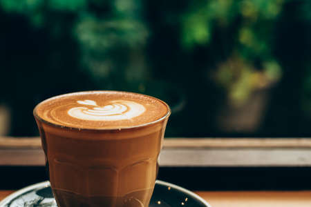 A cup of coffee latte top view with leaf shape foamの写真素材