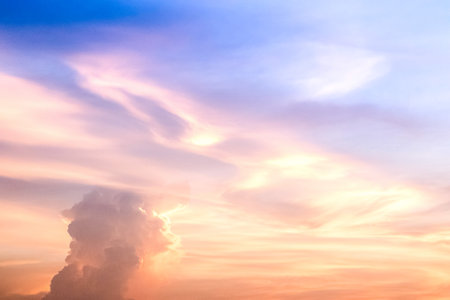 Sunset sky clouds in the evening on golden hour with orange sunlight sky backgroundの写真素材
