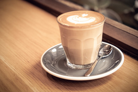 A cup of coffee latte top view with leaf shape foamの写真素材