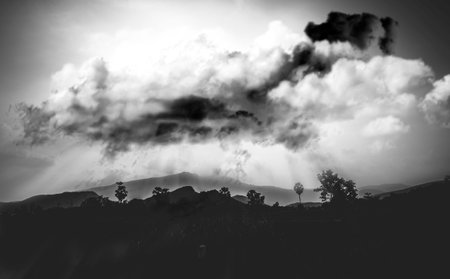 rainy clouds over mountains  Countryside road  in a spectacular summer sunset . Black and white