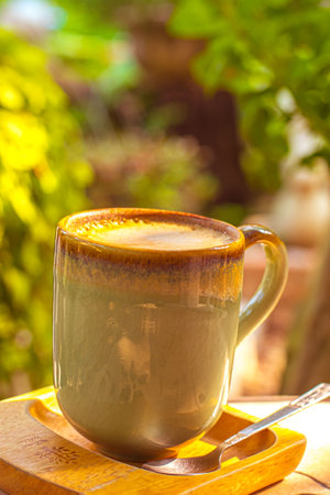 coffee, books on table in summer garden. Rest in garden, reading books, breakfast, vacations in nature concept. Summertime in garden on backyardの写真素材