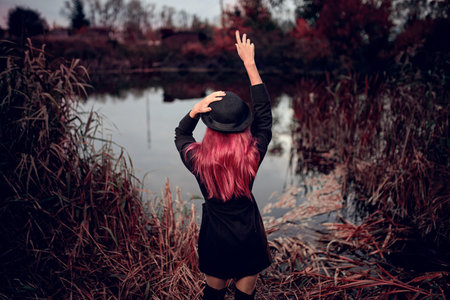 fashion outdoor autumn photo of beautiful woman with red hair in black hat and small black dress...
