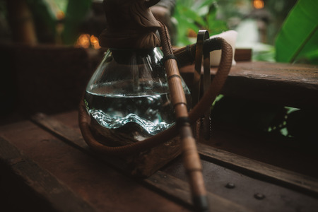 Photo of Asian hookah with autentic glass bowl is on the wood table in Baliの写真素材