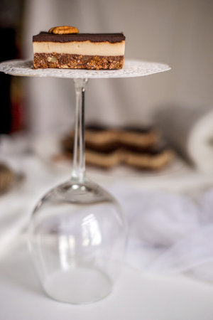 Very appetizing beautiful food photo of tasty chocolate authentic canadian dessert Nanaimo with nuts in healthy version - plant based and shugar free. Served on the elegant white plate on a white background.の写真素材
