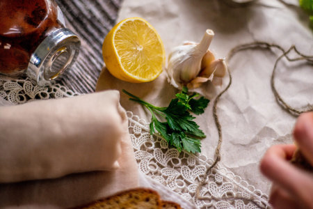 Beautiful food photo of lemon, garlic and parsley on craft paper on the dark wood table of kitchen