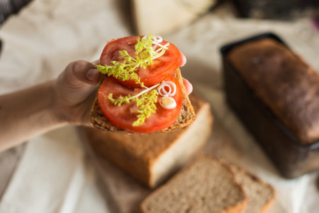 beautiful food photo of homemade sandwich with fresh sourdough wheat bread and tomato and some...