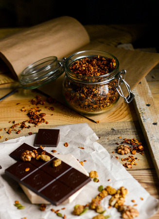 beautiful food photo of tasty dark chocolate with homemade granola on the rustic background wood tableの写真素材