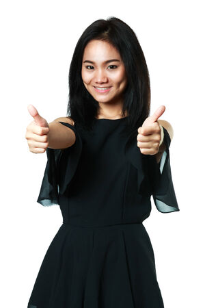 Young asian woman showing thumbs up, Isolated over whiteの写真素材