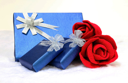 Gift box and red rose on a flannel backgroundの写真素材