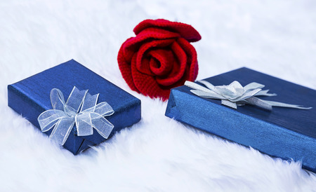 Gift box and red rose on a flannel backgroundの写真素材