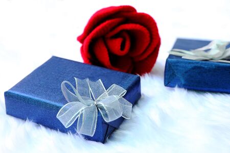 Gift box and red rose on a flannel backgroundの写真素材