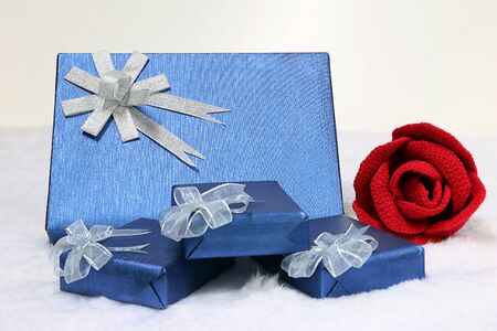 Gift box and red rose on a flannel backgroundの写真素材