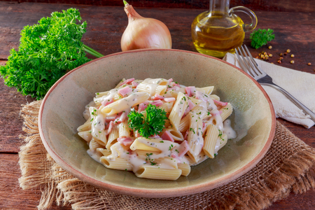 Pasta with ham Cream Sauce on wooden table.の写真素材