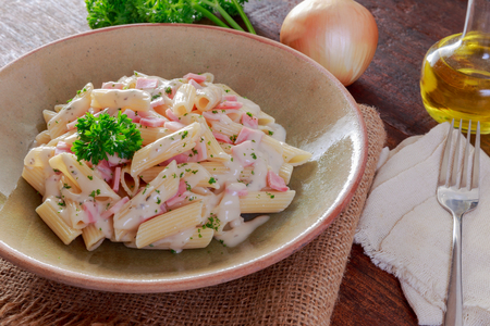 Pasta with ham Cream Sauce on wooden table.の写真素材