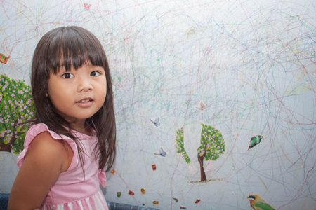 girl drawing with crayons on the wallpaper