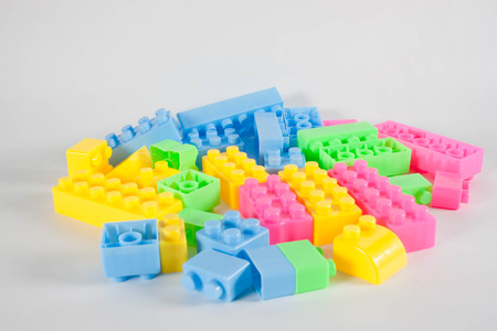 Pile of colorful plastic toy construction bricks isolated over the white as a  background.の写真素材