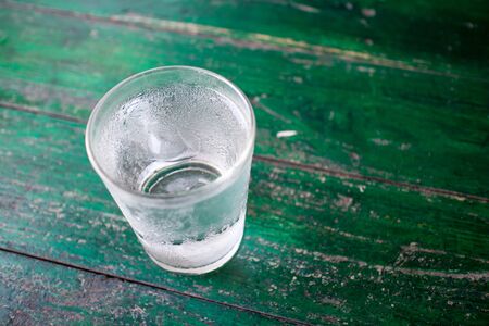 Close up drinking water with ice in glass on wooden table.の写真素材