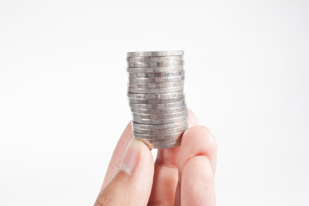 Close Up of human hand holding coins isolated on white background.の写真素材