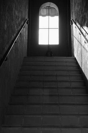 Black stairs scene of downward perspective stairs leading to window.のeditorial素材