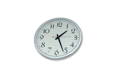 Round metal clock on white wall.の写真素材