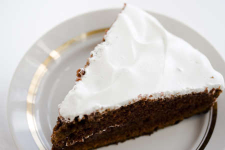 Chocolate cake with white cream on a white plateの写真素材