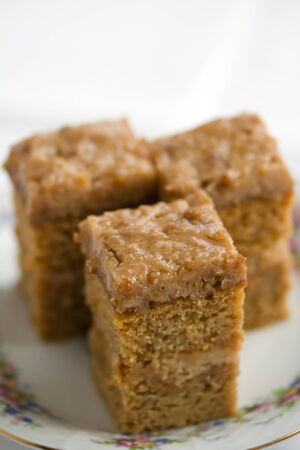 Three pieces of spicy cake with buttercream frosting and maple syrupの写真素材