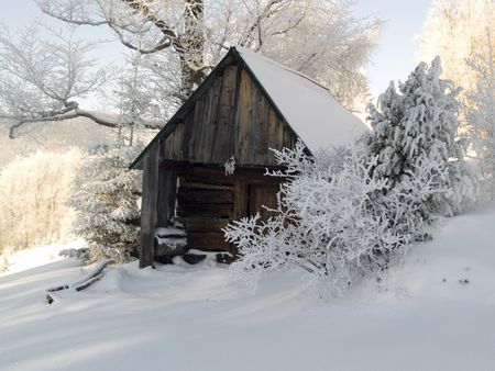 Small wooden cottage in winter. A lot of snow. Sunny dayの写真素材