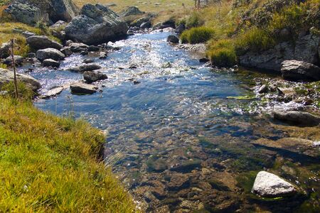 Pyrenees mountain, autumn day, sunlight in water, small brook.の写真素材