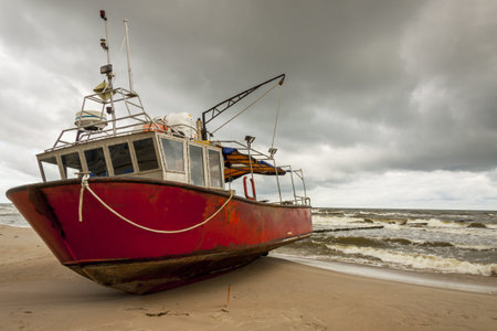Old fishing boat on the beach in Rewal - Poland.の写真素材