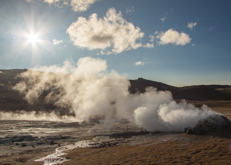Steam at high pressure of the Sulphurous hill Namafjall in Iceland  Blue sky with sun の写真素材