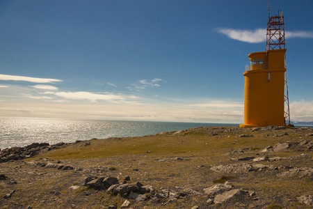 Small orange lighthouse on Hvalnes - coast of Iceland.の写真素材