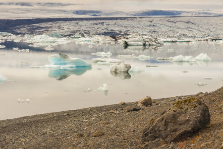 Big stone on coast of glacier lake - Jokulsarlon lagoon, Iceland.