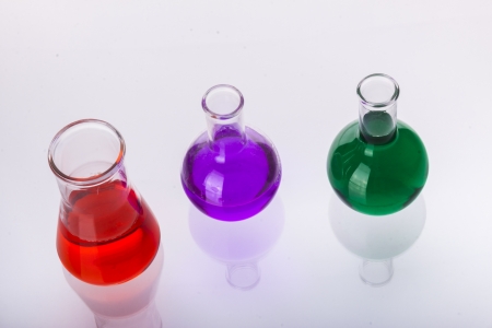 Laboratory glassware with liquids of different colors on white background.の写真素材
