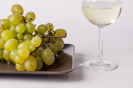 White grapes with a glass of white wine on white backgroundの写真素材