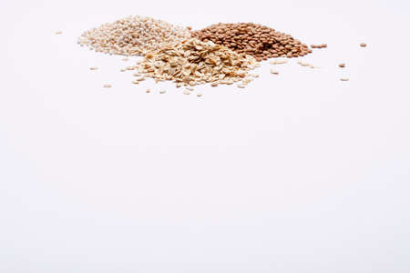 Three piles of grits, lentil and oatmeal - white background の写真素材