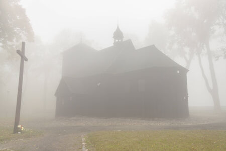 Old wooden church on foggy day - Poland.の写真素材
