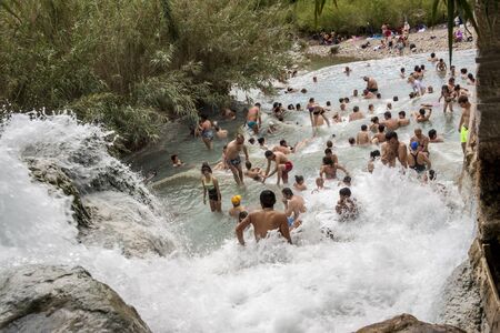 SATURNIA, ITALY - MAY 1, 2019: Tourists swimming and relaxing in hot springs in Saturnia at Mulino natural waterfalls by Manciano municipality in tuscan Maremma on May 1,2019 in Saturnia, Italy.のeditorial素材