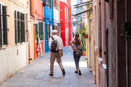 Burano, ITALY -  MAY 2, 2019: Tourist on street of old Colorful city of Burano on May 2,2019 in Burano island in Italy. View on Colorful houses.のeditorial素材