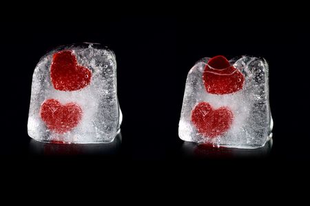 Four hearts in melting icecubes with small reflection on black backgroundの写真素材
