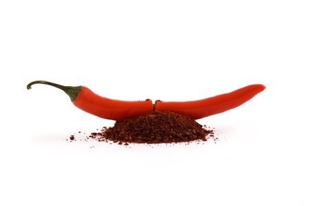 Chili pepper cut in half with spice pouring out focus in center and isolated white backgroundの写真素材