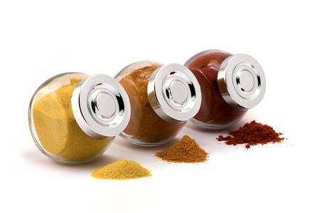 Three jars with spices on isolated white background, focus at closest jar capの写真素材