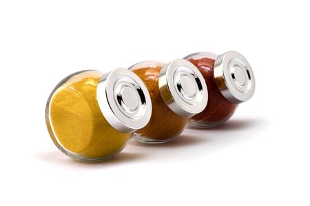 Three jars with filled with spices on isolated white background, focus at 2nd jar capの写真素材