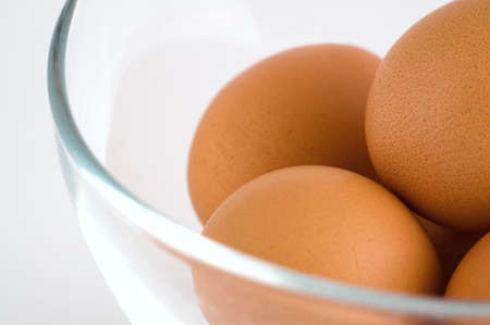 A few eggs in glass bowl in closeup at isolated white backgroundの写真素材