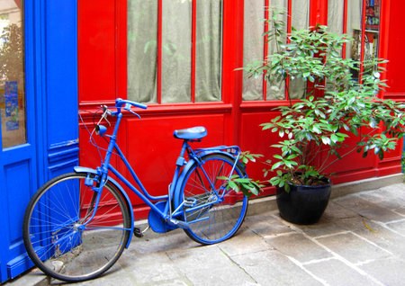 Blue bicycle in front of a red door in Paris, France.の写真素材