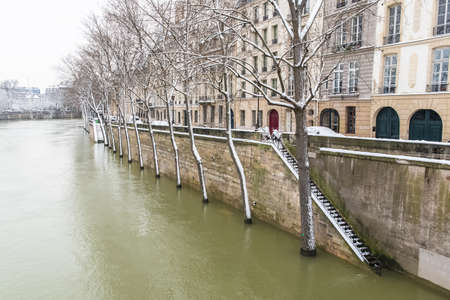 Paris under the snow and floods, flooded quays, trees under the water, the Seine in winterの写真素材