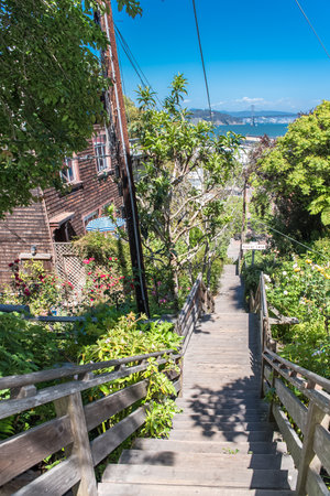 San Francisco, charming wooden staircase in Napier Lane, Telegraph Hill, with the Oakland Bay Bridge in backgroundのeditorial素材