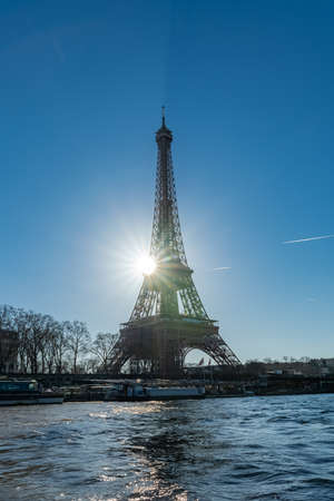 Paris, the Eiffel Tower in backlight, full sun in winter, with houseboats on the Seineの写真素材