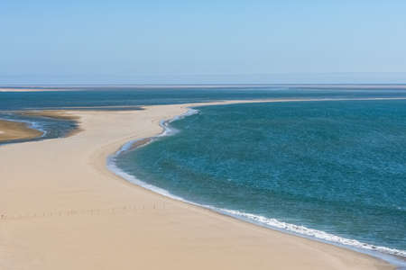Namibia, the Namib desert, landscape of yellow dunes falling into the seaの写真素材